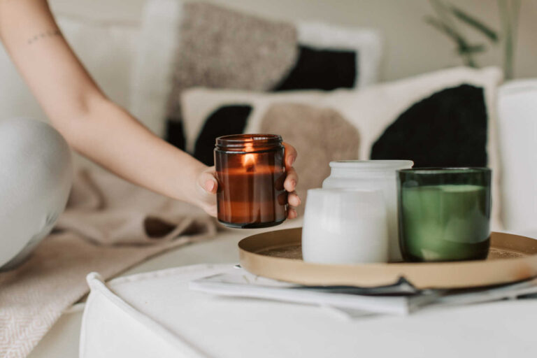 Person holding one of several mindful candles during a relaxing home meditation and self-care routine.