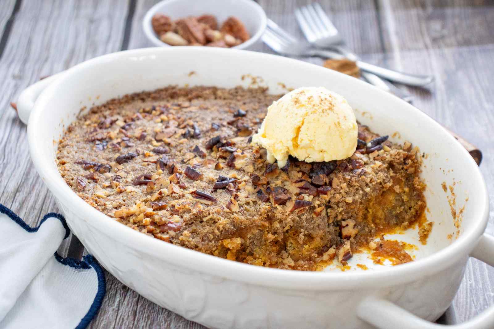 Clean Eating Pumpkin Pie Dump Cake with pecans and vanilla ice cream.