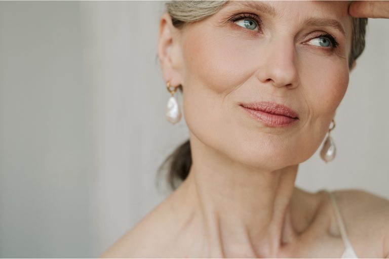 Woman wearing baroque pearl drop earrings with gold hoops, an elegant idea for gifting fine jewelry.